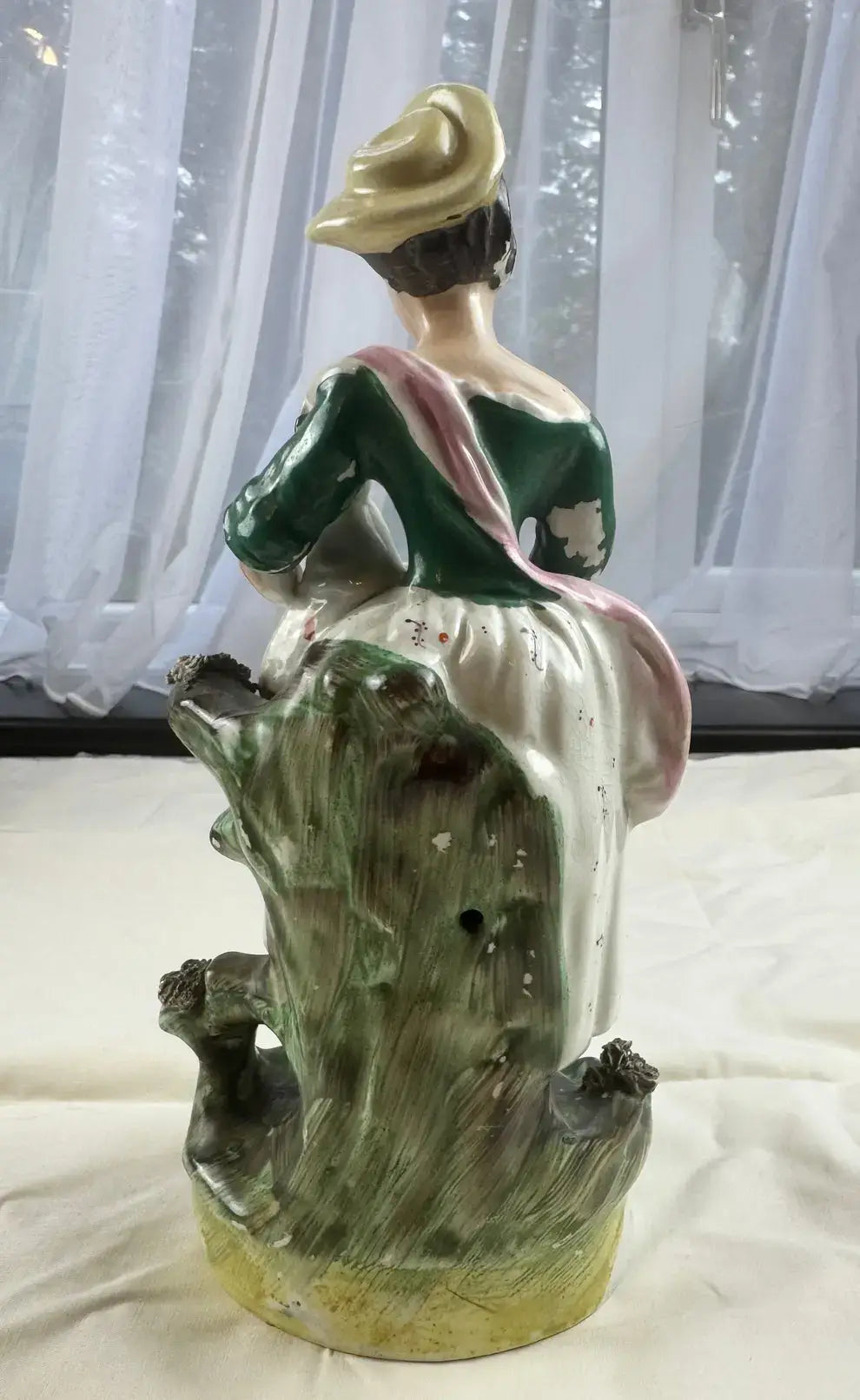 19th-century Staffordshire figurine of a woman in a bonnet, showcasing detailed craftsmanship and tranquil Victorian charm.