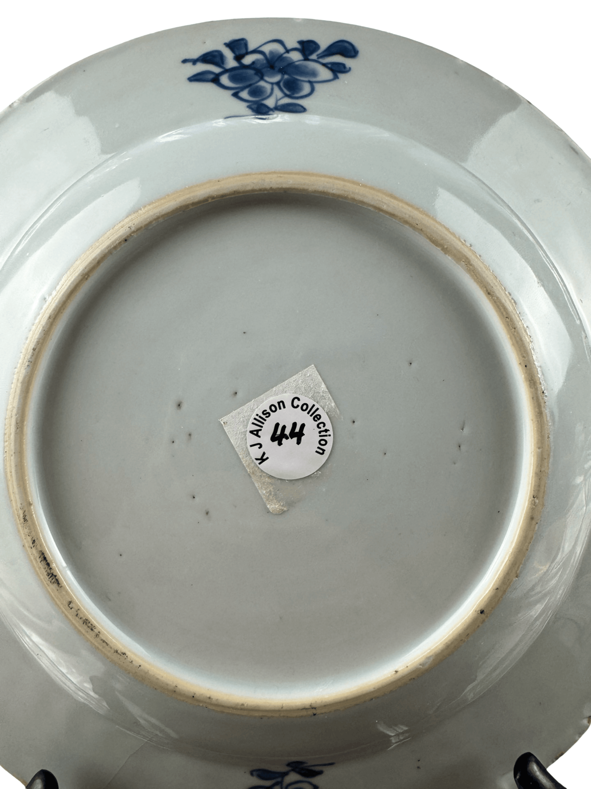 Underside of Chinese Qianlong blue and white plate, featuring K J Allison collection mark and decorative floral design.